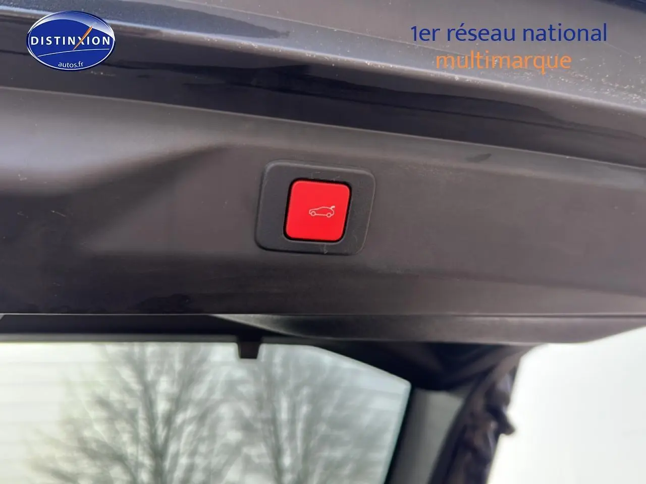 Bouton rouge d'ouverture électrique du coffre sur le hayon intérieur du Peugeot 3008 gris Artense 2025.