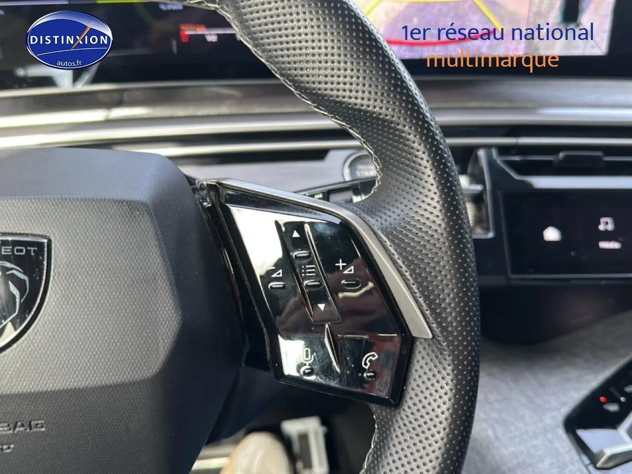 Gros plan sur le volant cuir perforé du Peugeot 3008 gris Artense, avec commandes audio et téléphone intégrées.