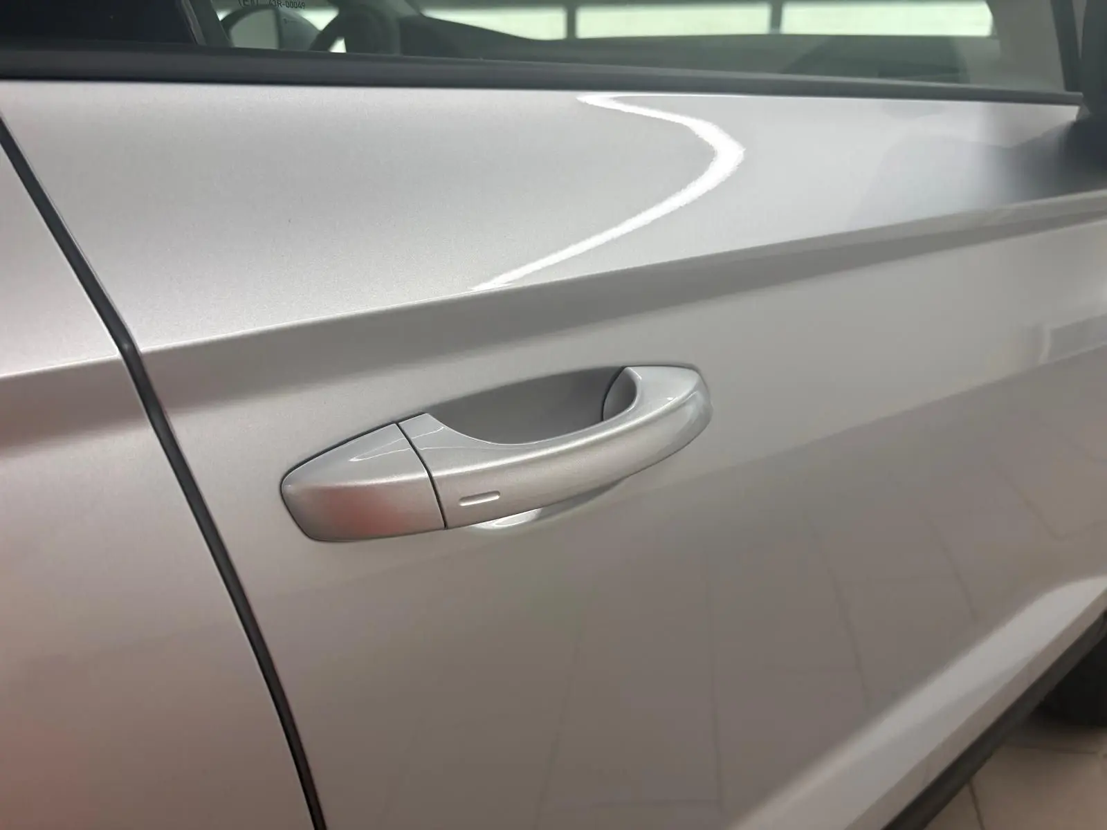 Poignée de porte côté gauche d'un SEAT Ateca 2025 Argent Reflex avec peinture métallisée brillante.