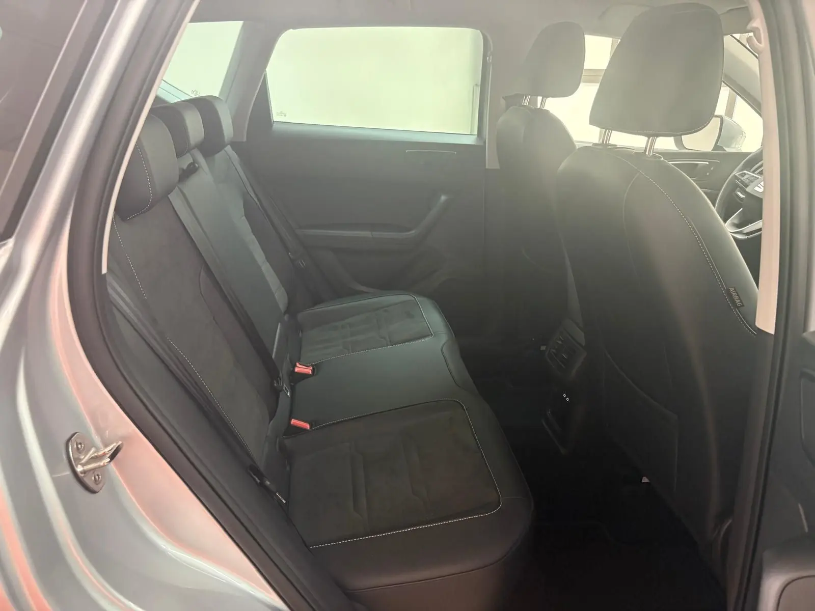 Vue intérieure côté gauche montrant la banquette arrière en cuir noir du SEAT Ateca 2025 Argent Reflex.