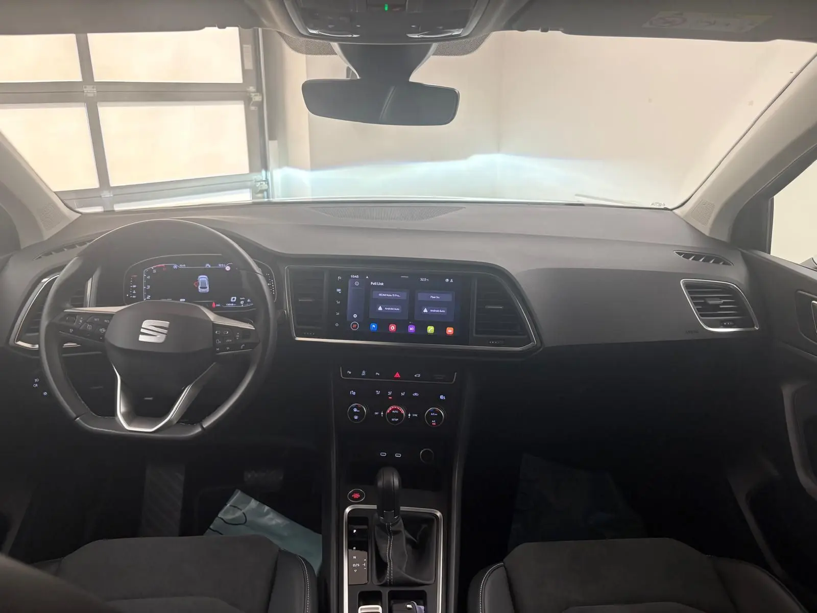 Vue intérieure avant du tableau de bord du SEAT Ateca 2.0 TDI 150 DSG7, avec écran tactile central et volant multifonction.