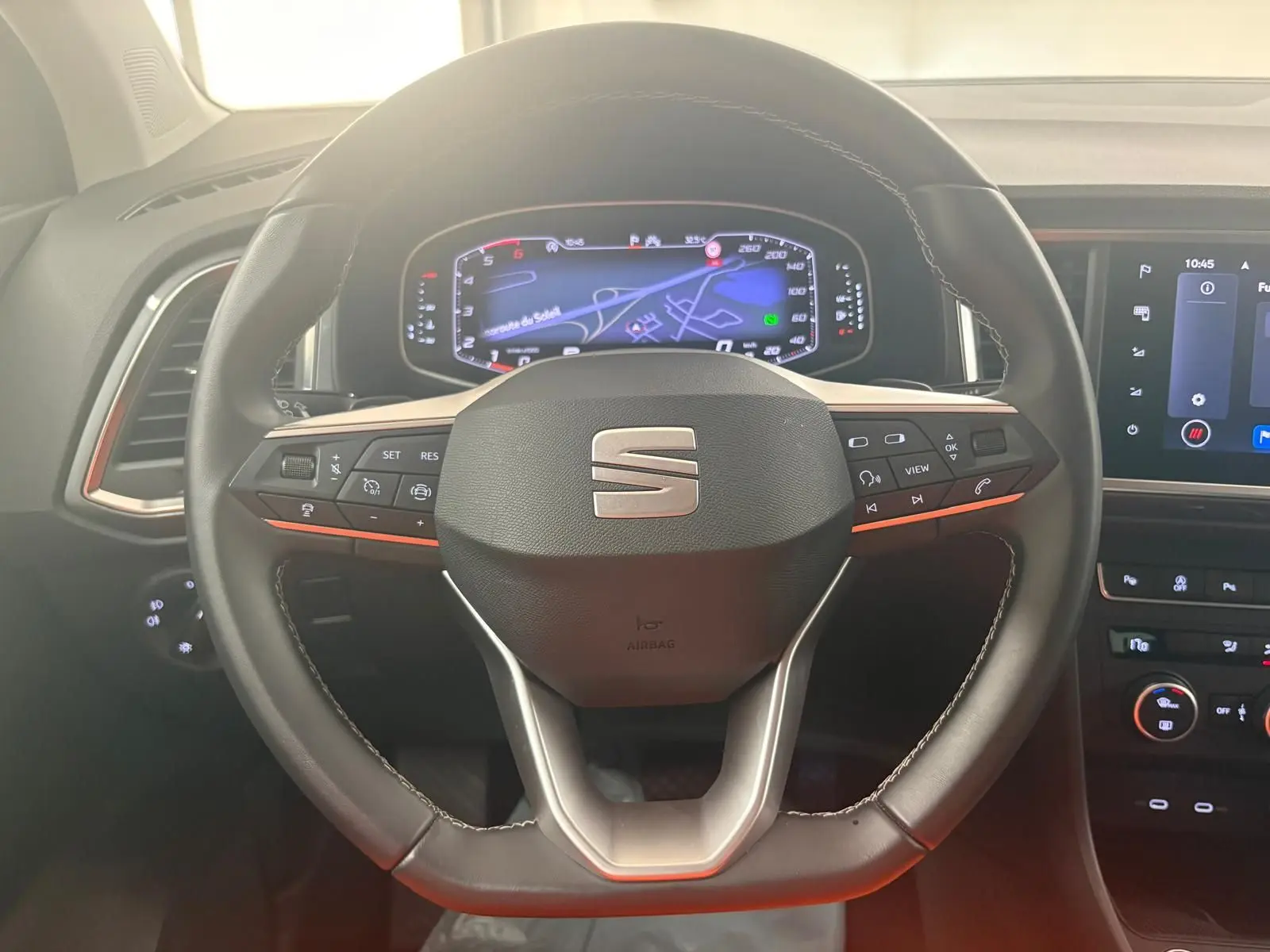 Vue rapprochée du volant multifonction noir avec logo SEAT et tableau de bord numérique du SEAT Ateca 2025.