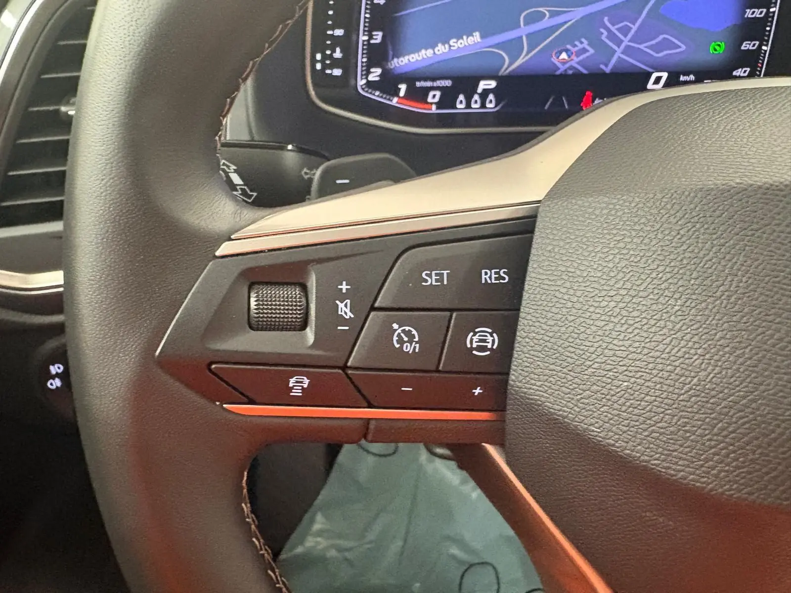 Gros plan sur les commandes au volant côté gauche du SEAT Ateca 2.0 TDI 150 DSG7 2025 avec tableau de bord numérique.