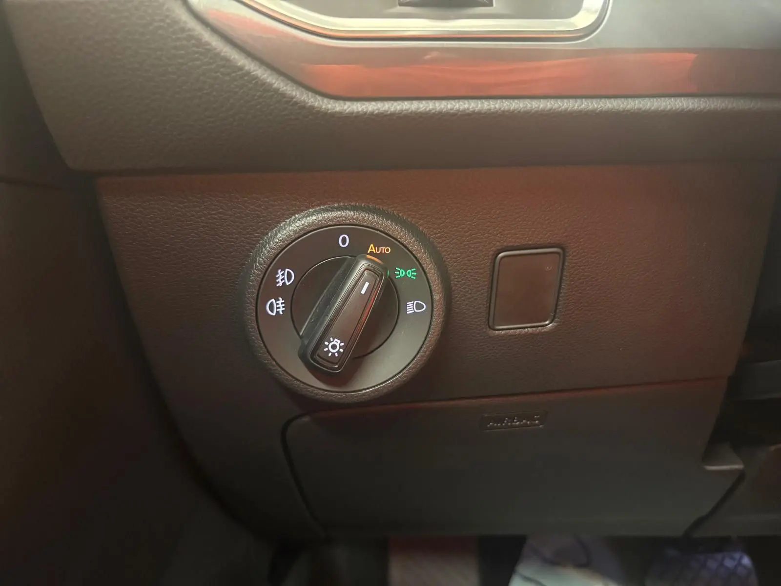 Gros plan sur le bouton de commande des phares du SEAT Ateca 2025, avec éclairage automatique activé.