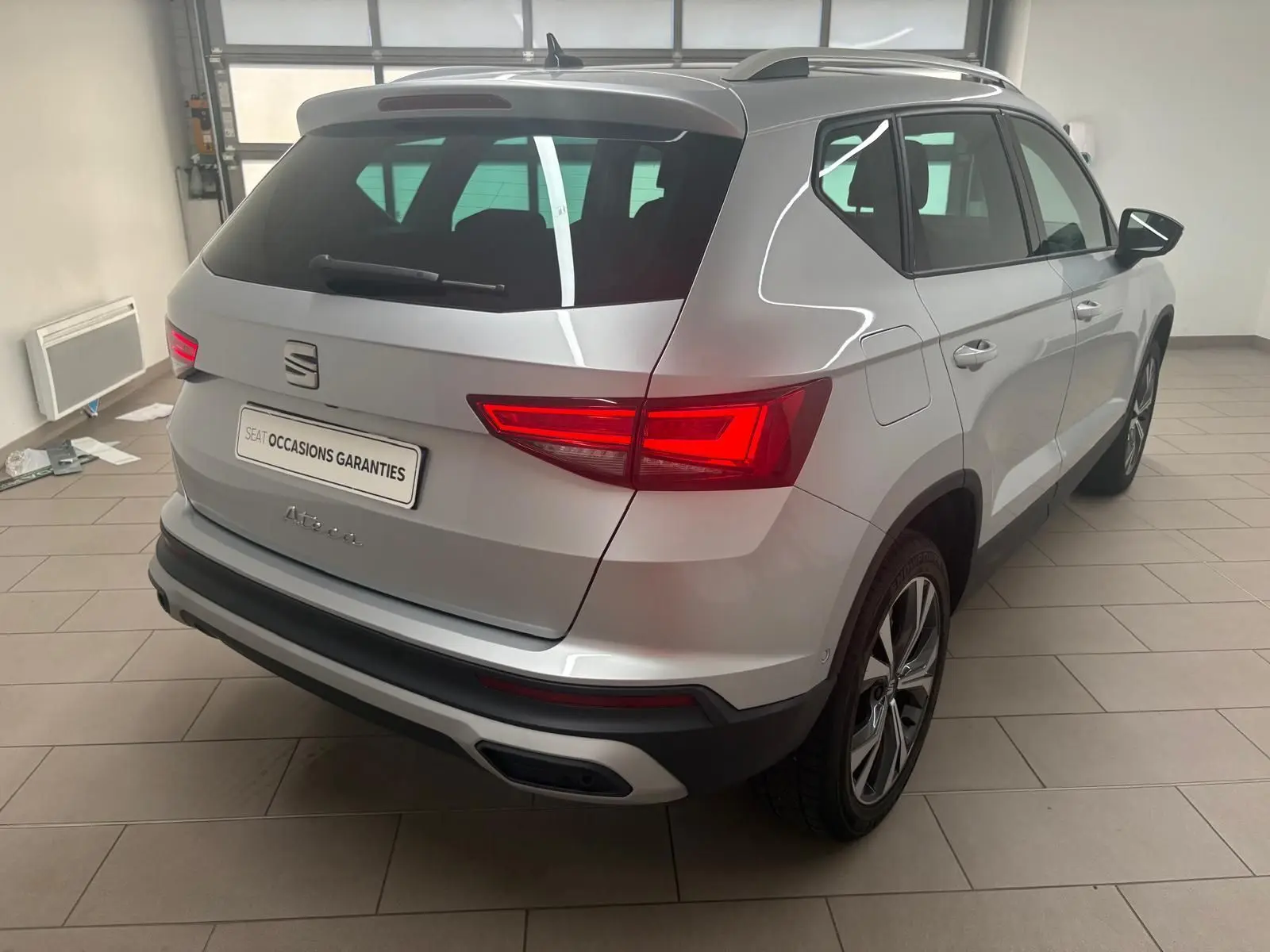 Vue 3/4 arrière droite du SEAT Ateca 2025 en Argent Reflex, avec hayon électrique et jantes alliage 18 pouces.