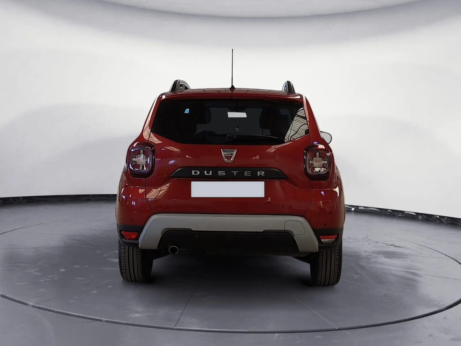 Vue arrière d'un Dacia Duster rouge fusion 2021 avec logo et feux arrière caractéristiques bien visibles.