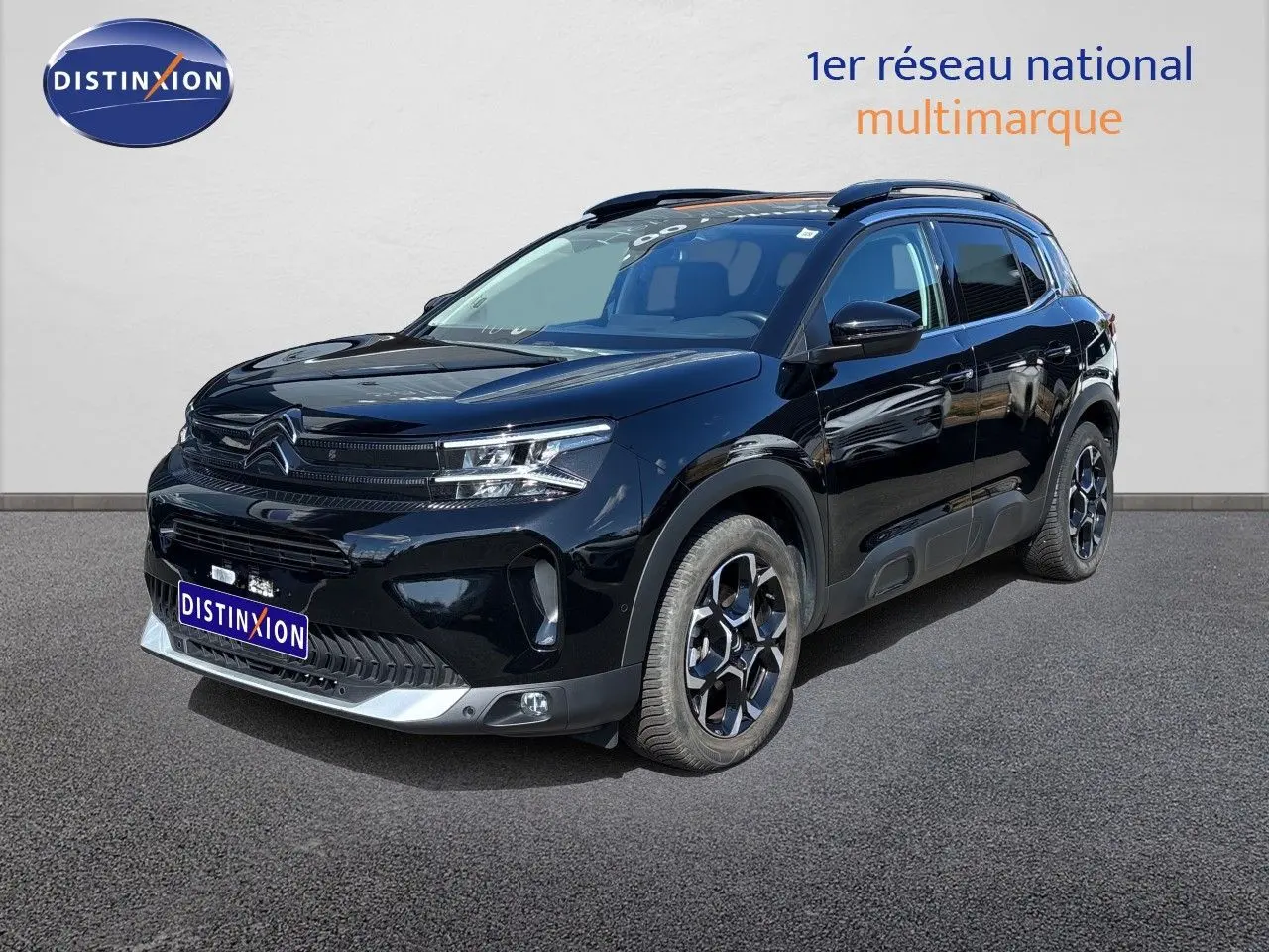 SUV Citroën C5 Aircross noir Perla Nera, vue 3/4 avant droit, avec jantes bicolores et toit panoramique.