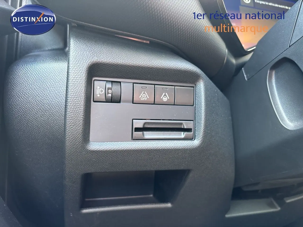 Gros plan sur les commandes de réglage d’éclairage et d’aide à la conduite côté gauche du tableau de bord noir du Citroën C5 Aircross 2025.