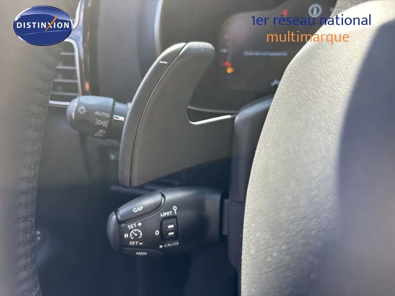 Gros plan sur la commande de régulateur de vitesse et la palette de changement de vitesse côté gauche du volant du Citroën C5 Aircross noir.