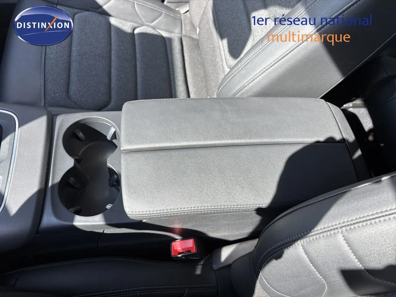 Vue rapprochée de l'accoudoir central et des sièges noirs en tissu du Citroën C5 Aircross 2025, finition hybride.