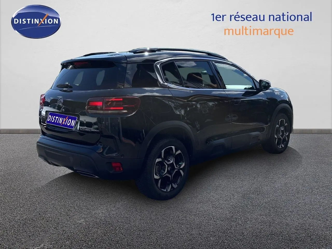 Vue 3/4 arrière droite d'un Citroën C5 Aircross noir Perla Nera métallisé avec jantes noires et toit panoramique.