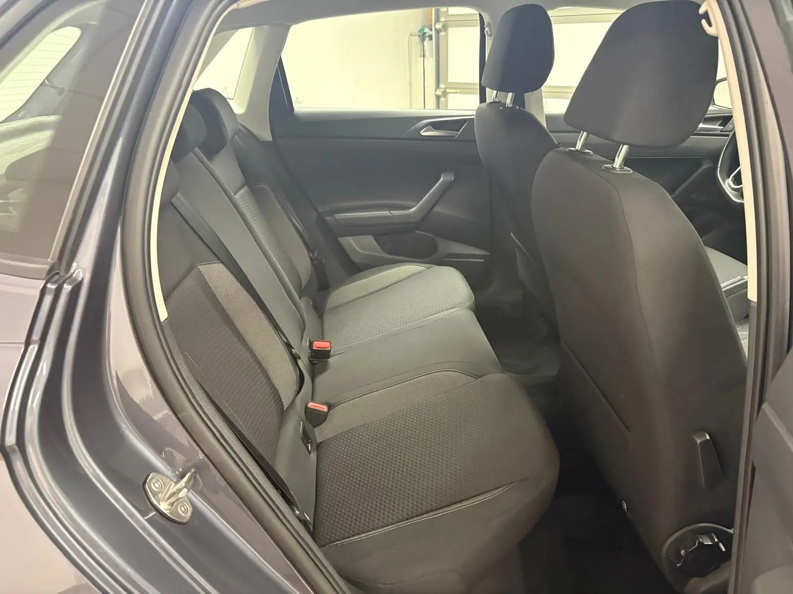 Vue intérieure côté gauche sur les sièges arrière noirs d'une Volkswagen Polo gris cendre 2024, version Life Plus.
