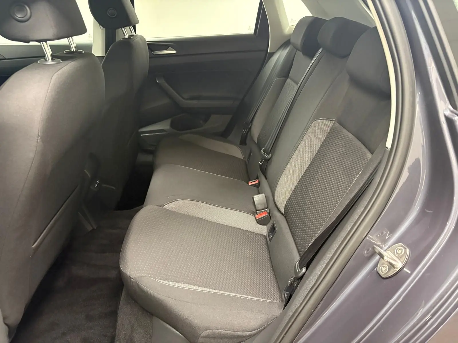 Vue intérieure côté droit sur les sièges arrière gris foncé de la Volkswagen Polo 2024 gris cendre.