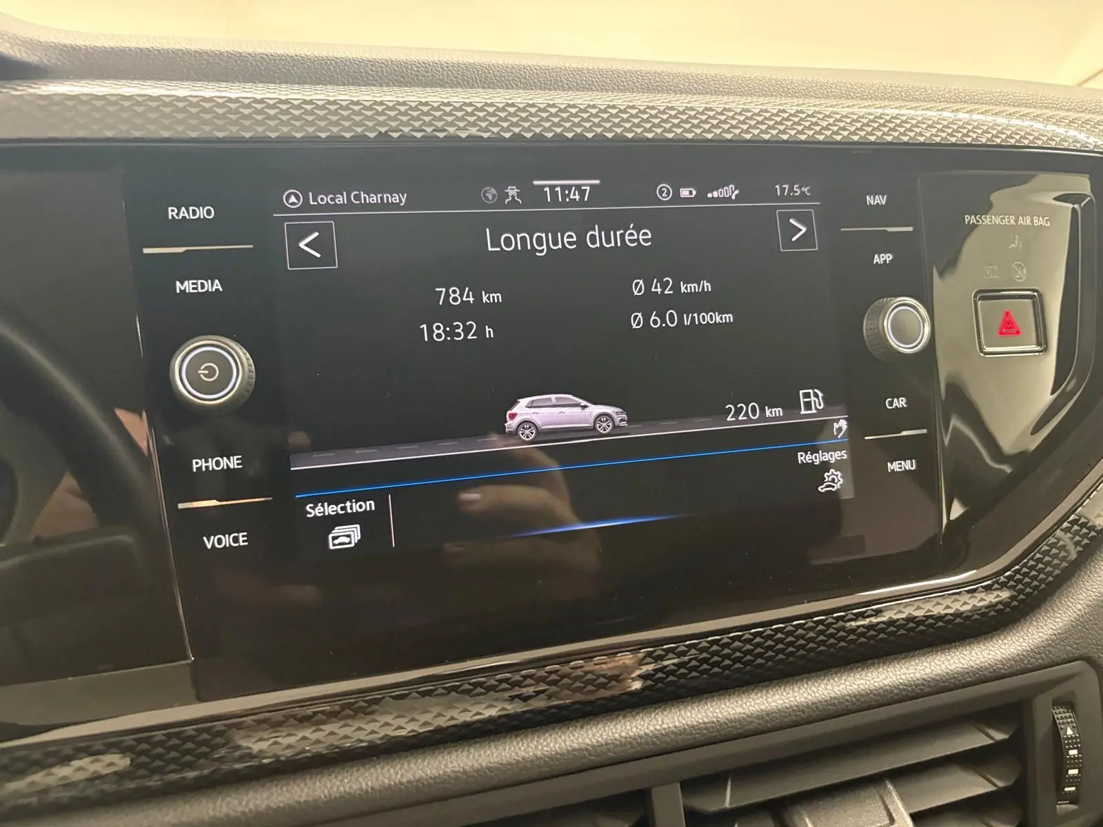 Écran tactile central de la Volkswagen Polo 2024 affichant les données de conduite longue durée, avec boutons de commande autour.