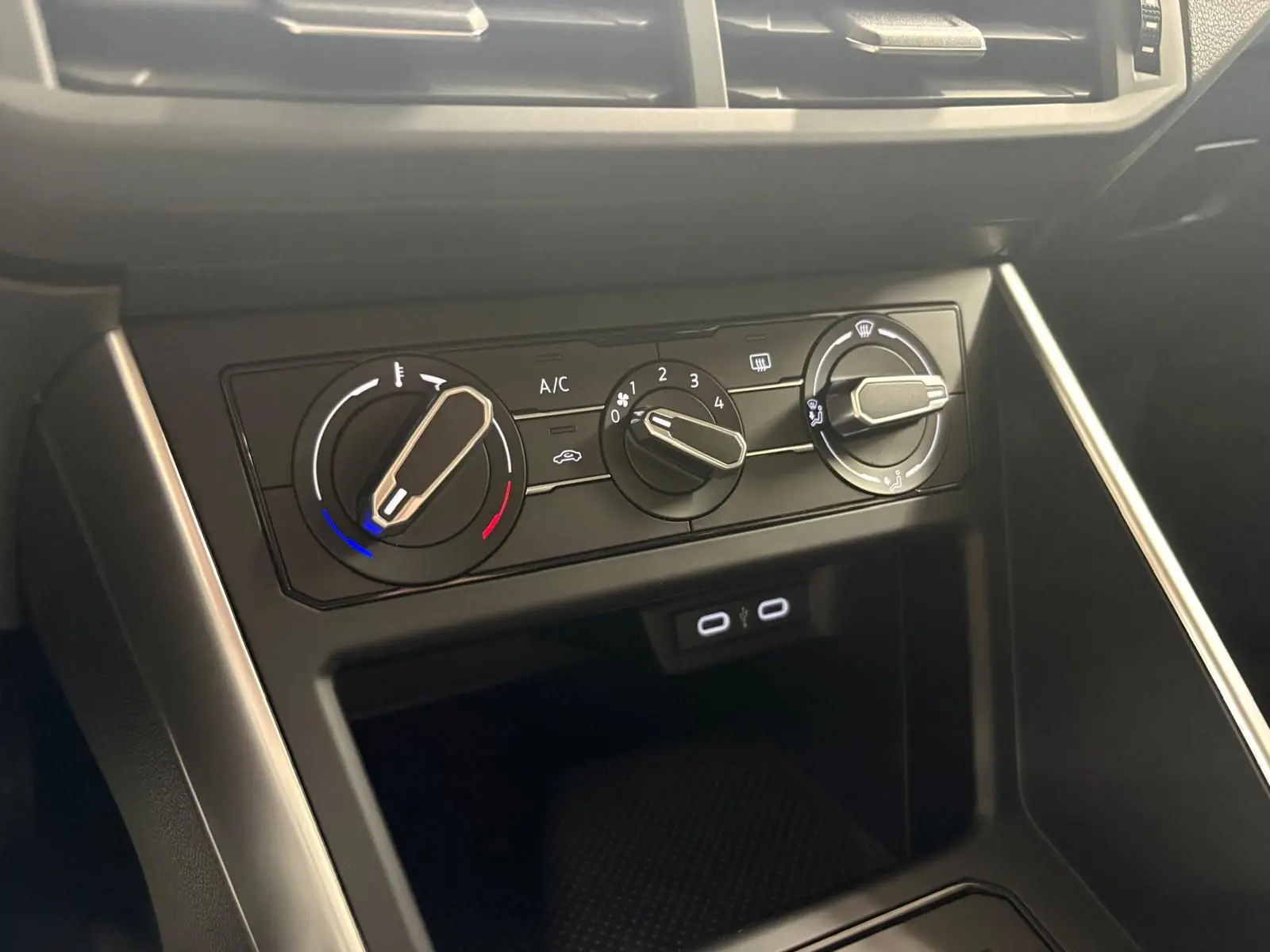 Gros plan sur les commandes de climatisation de la Volkswagen Polo gris cendre 2024, avec boutons rotatifs et ports USB.
