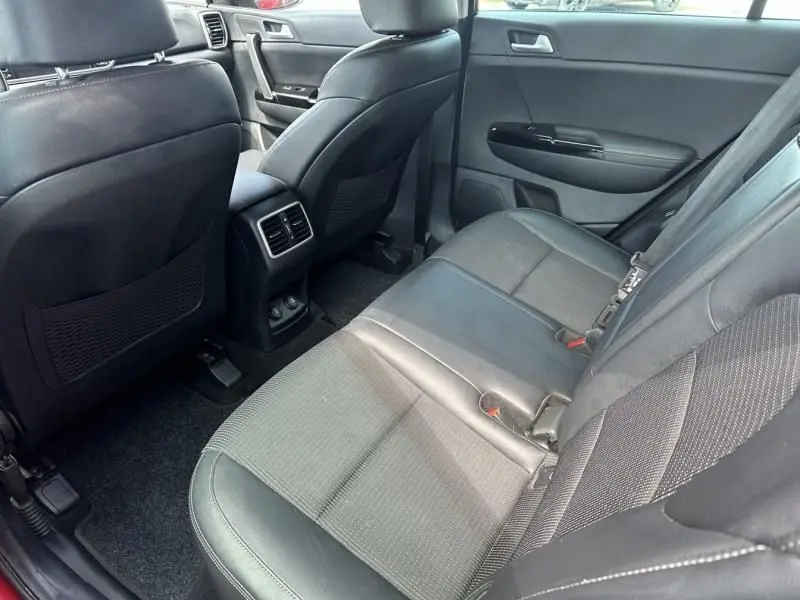 Vue intérieure arrière côté droit du Kia Sportage 2021, sièges en cuir noir et aérateurs centraux visibles.