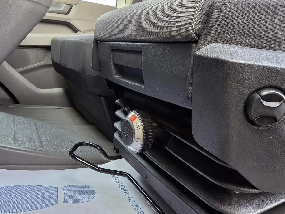 Vue rapprochée du réglage de siège noir dans l'habitacle du Volkswagen Crafter Fourgon blanc 2023.