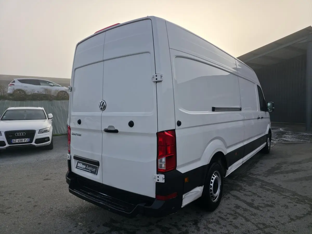 Vue 3/4 arrière droite d'un utilitaire Volkswagen Crafter blanc avec portes arrière fermées et jantes acier.