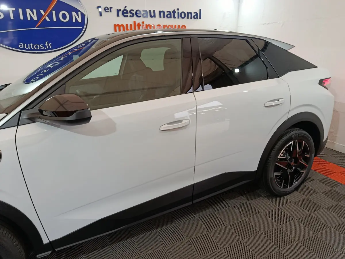 Profil côté gauche du Peugeot 3008 blanc hybride 2025 avec toit noir et jantes alliage noires.