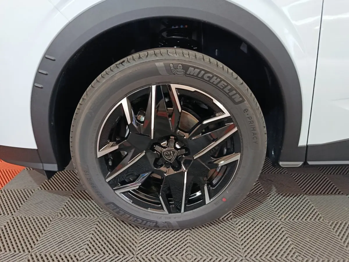 Gros plan sur la roue avant gauche du Peugeot 3008 blanc, jante alliage noire et argent avec pneu Michelin.