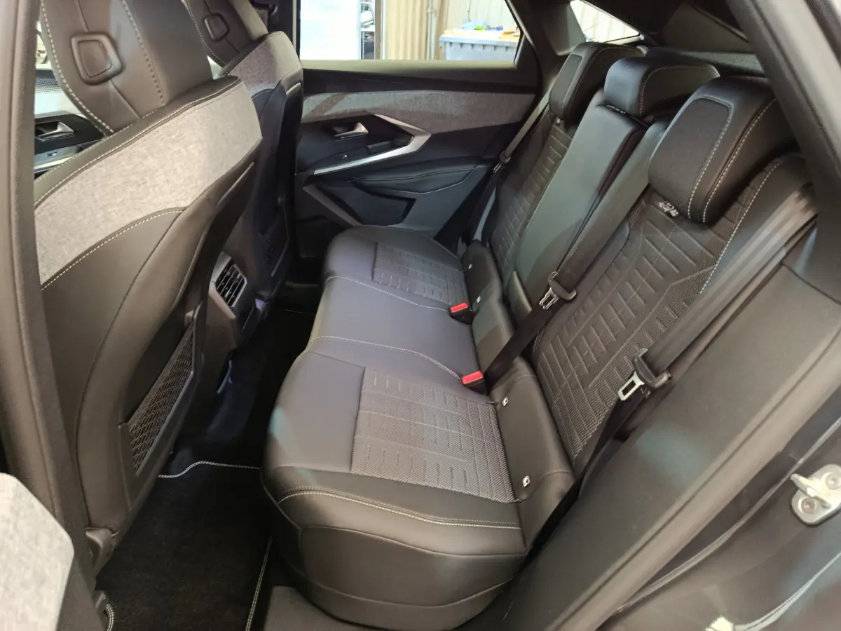 Vue latérale droite de la banquette arrière en cuir noir et tissu gris du Peugeot 3008 1.2 HYBRID 145 GT 2025.