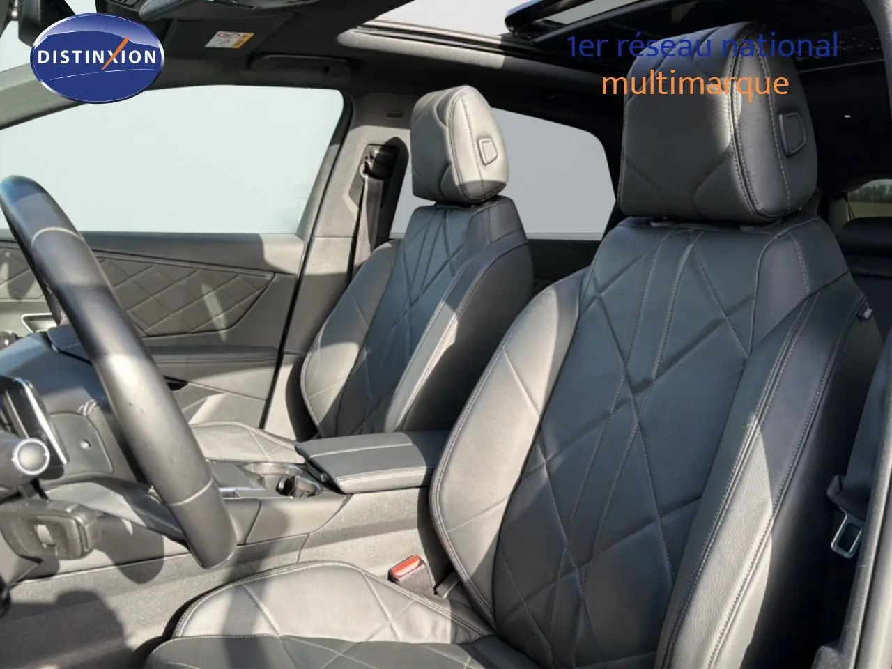 Vue intérieure côté conducteur du DS7 2024, sièges avant en cuir noir avec surpiqûres losanges et toit panoramique.