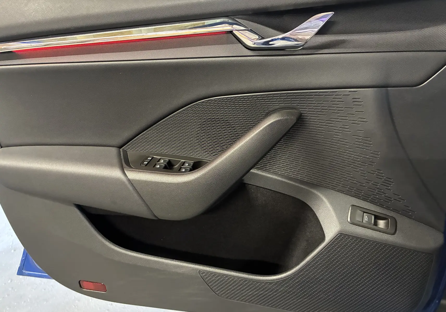 Vue rapprochée de la porte intérieure côté gauche de la Skoda Octavia Combi 2024, avec garniture noire et commandes de fenêtres.
