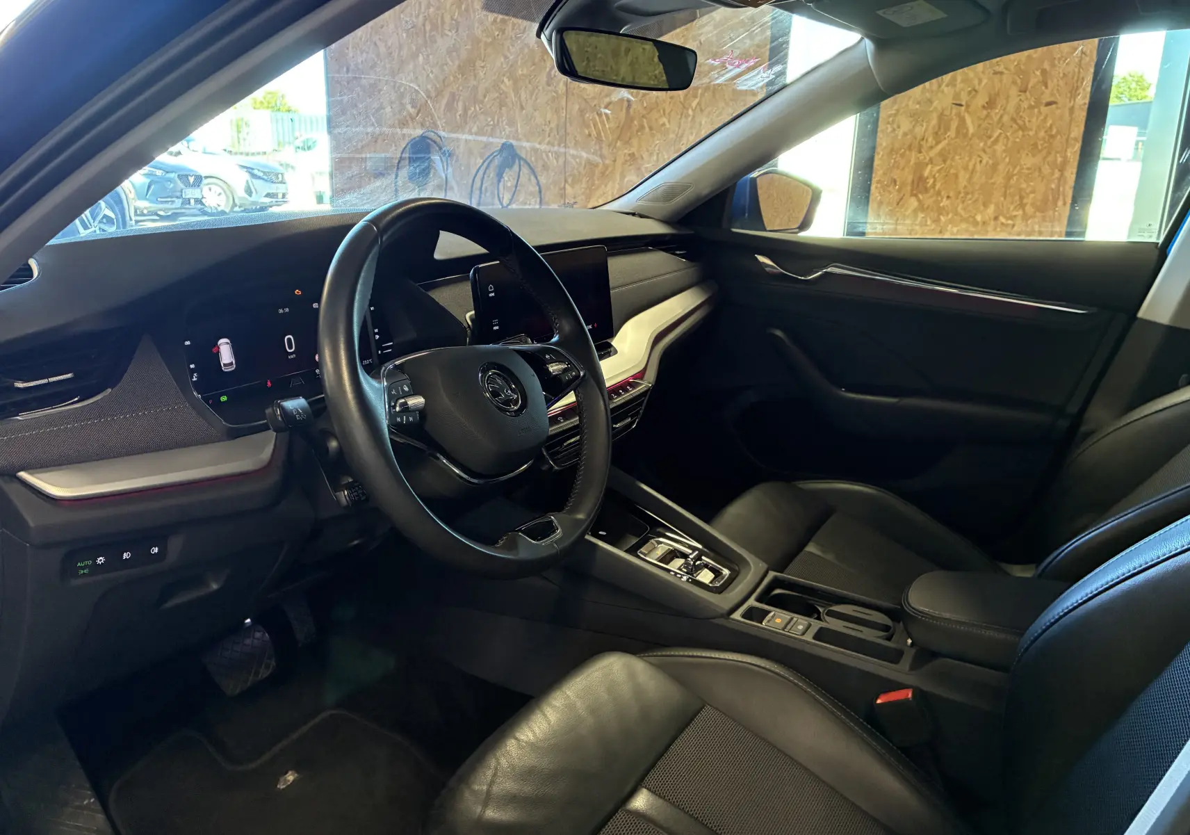 Vue intérieure côté conducteur de la Skoda Octavia Combi 2024, tableau de bord noir avec écran digital et volant multifonction.