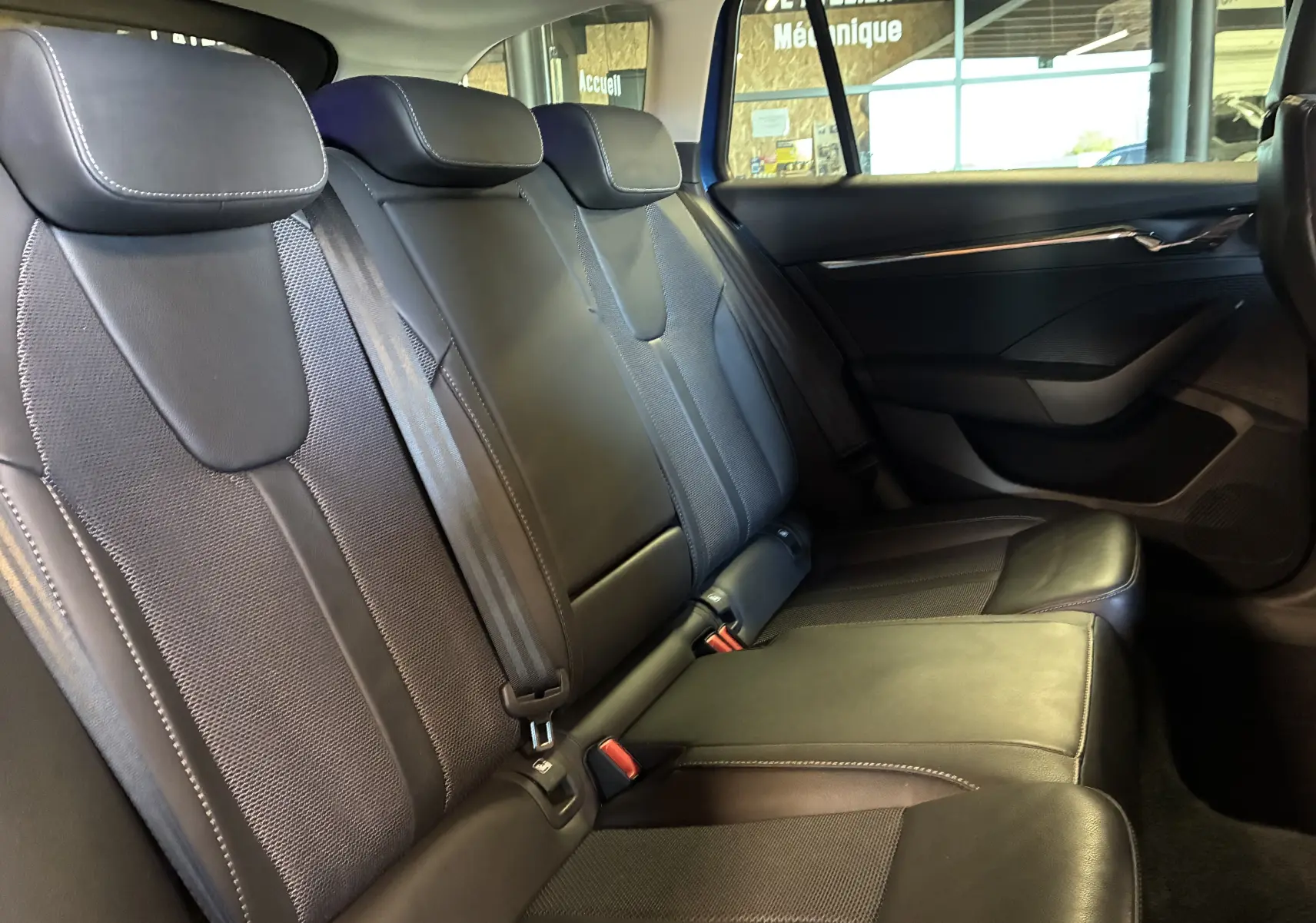 Vue latérale droite des sièges arrière en tissu noir et cuir de la Skoda Octavia Combi 2024, intérieur spacieux et soigné.
