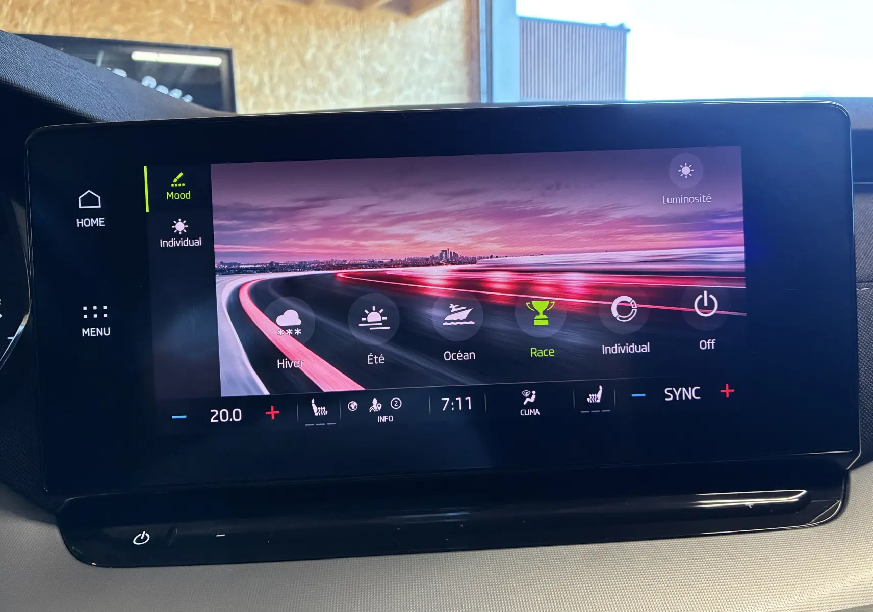 Écran tactile intérieur de la Skoda Octavia Combi 2024 affichant les modes de conduite avec fond paysage au coucher du soleil.