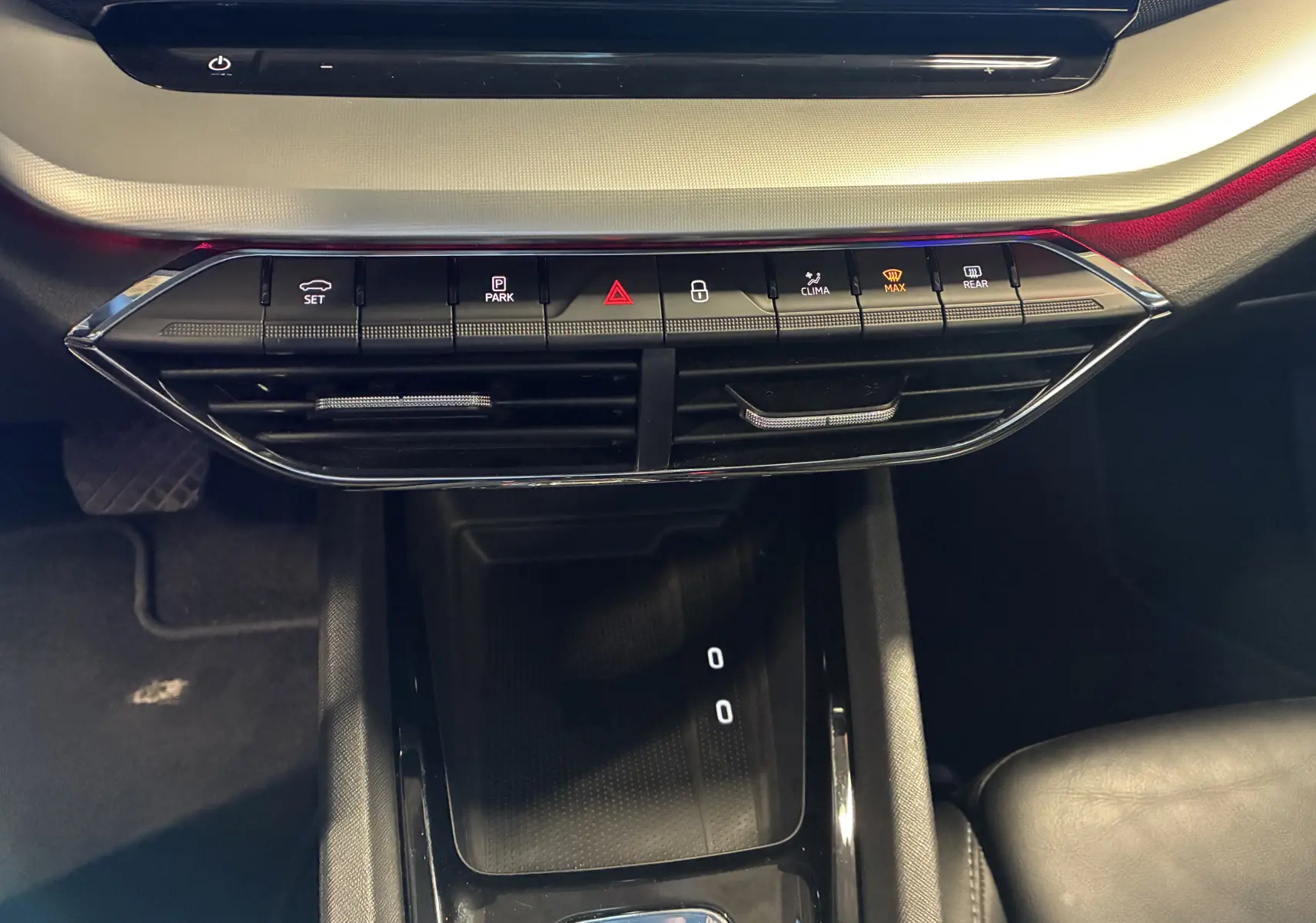 Vue rapprochée de la console centrale noire de la Skoda Octavia Combi 2024 avec boutons de climatisation et ventilation.