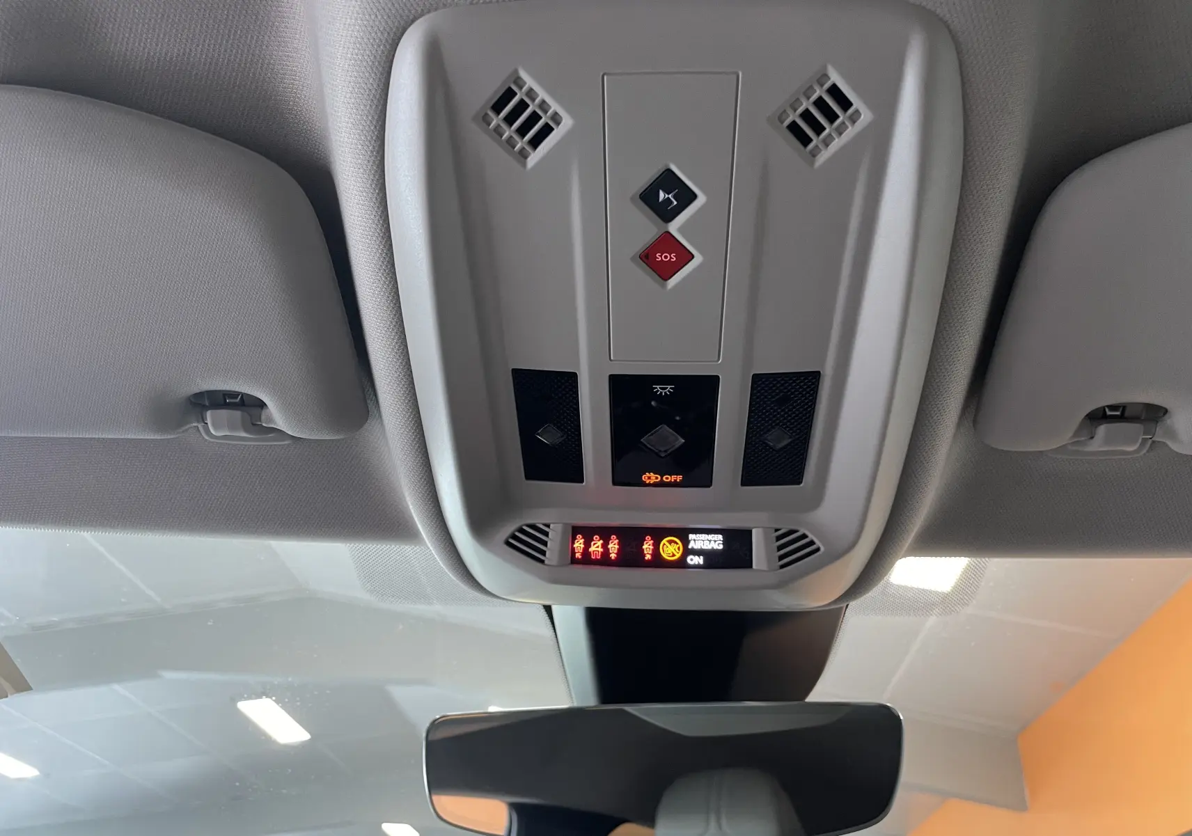 Vue intérieure du plafonnier gris clair avec commandes SOS et affichage des ceintures dans un DS3 Crossback Perla Nera 2024.