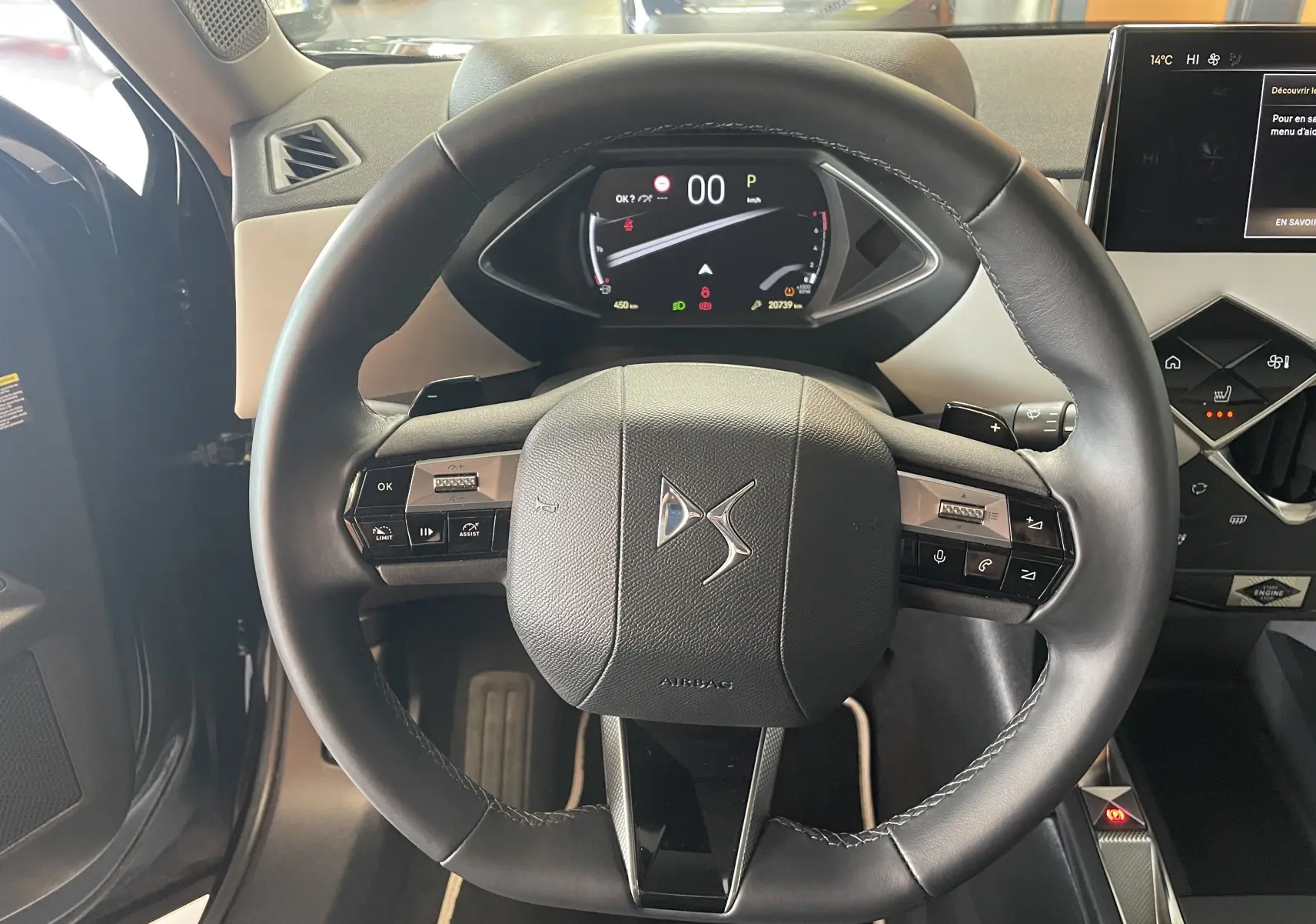 Vue rapprochée du volant en cuir noir du DS3 Crossback 2024 avec tableau de bord numérique et commandes intégrées.