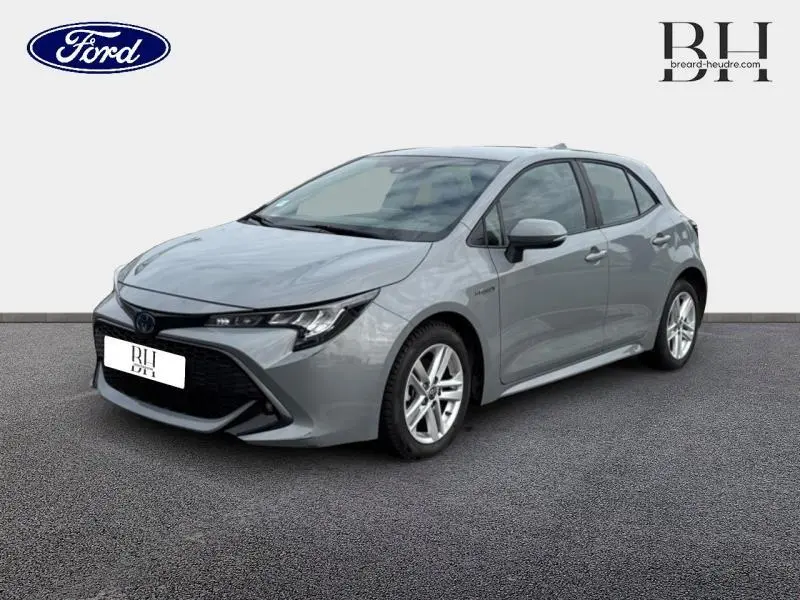 Toyota Corolla 122h Dynamic Business gris Manhattan métallisé vue 3/4 avant droit sur fond neutre.