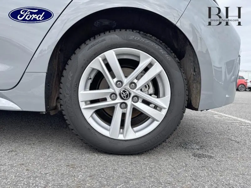 Gros plan sur la roue avant gauche gris Manhattan métallisé d'une Toyota Corolla 122h Dynamic Business MY19 avec jante alu à cinq branches.