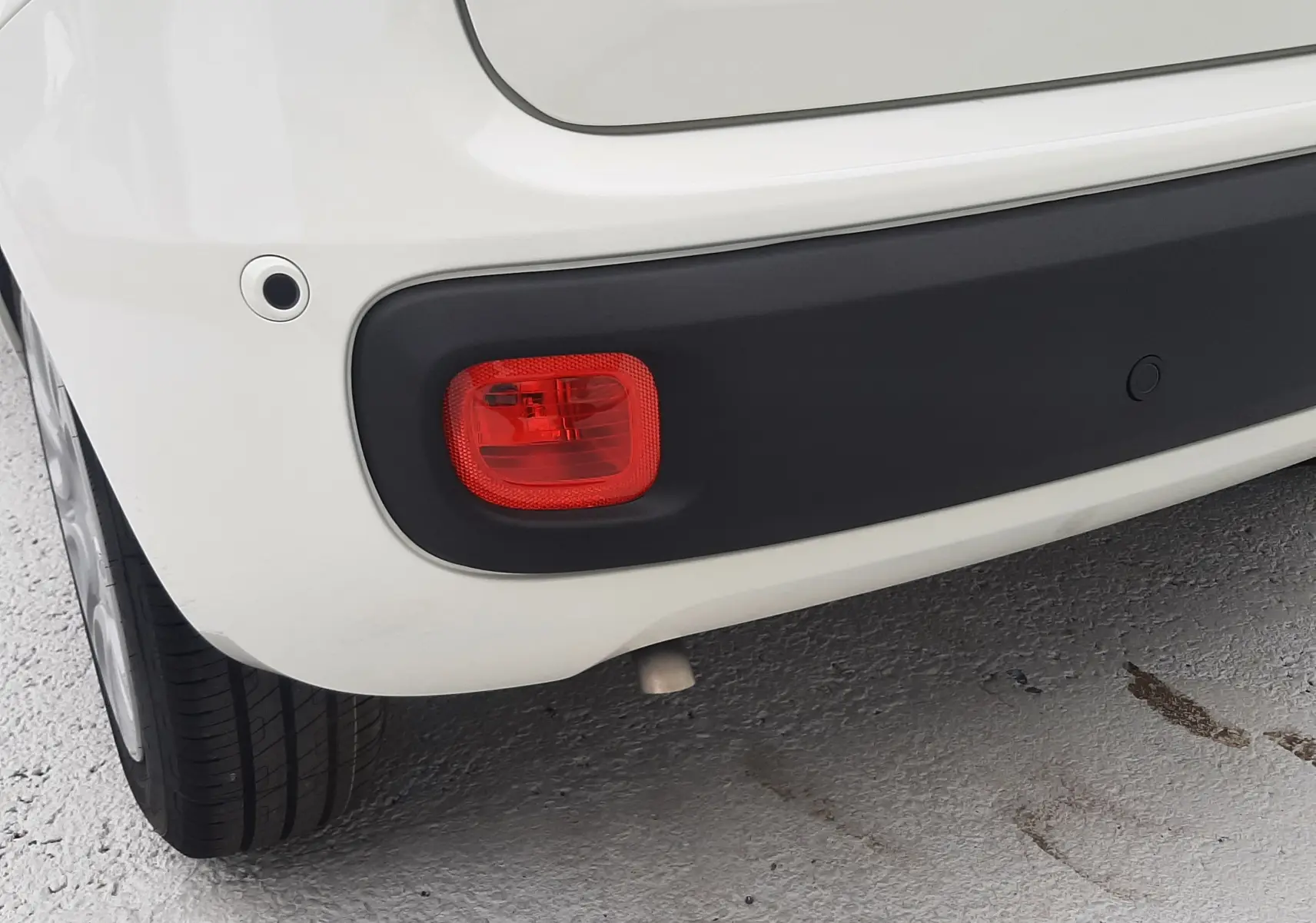 Gros plan sur le feu arrière droit et le pare-chocs noir d'une Fiat Panda 1.0 blanc gelato, vue arrière côté droit.