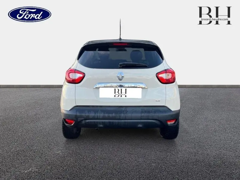 Vue arrière d'un Renault Captur beige cendré avec toit noir étoilé, feux arrière rouges et bouclier noir.