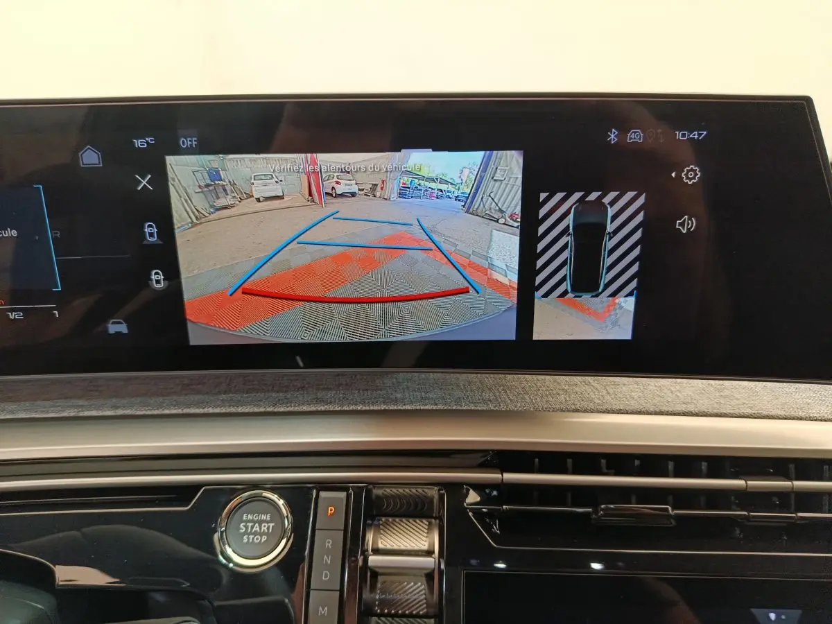 Vue rapprochée de l'écran tactile central du Peugeot 3008 noir 2025 montrant la caméra de recul et l'aide au stationnement.