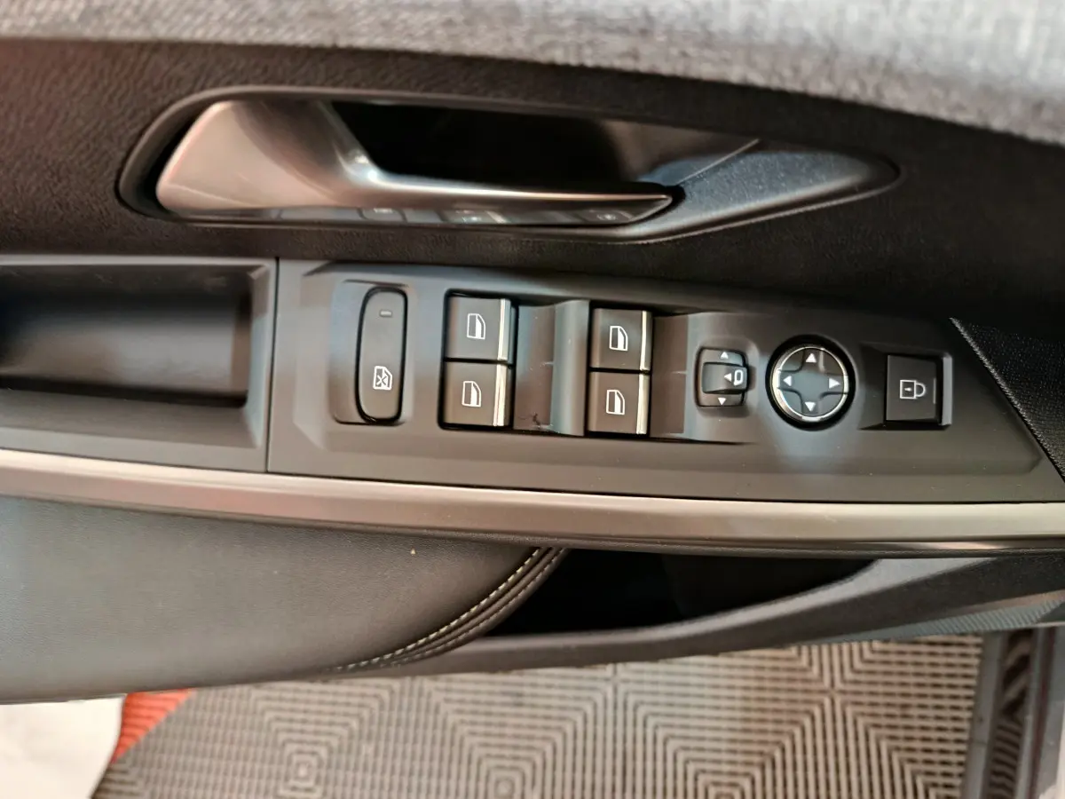 Commande des vitres et rétroviseurs côté conducteur du Peugeot 3008 noir hybride 2025, avec poignée argentée.