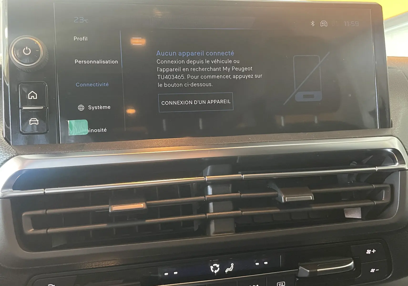 Écran tactile central du Peugeot Traveller 2026 noir, affichant le menu de connexion des appareils, avec commandes de climatisation en dessous.