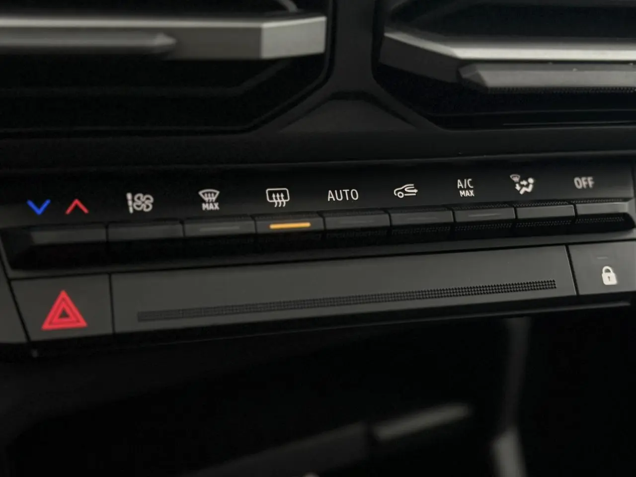 Détail de la console centrale du Dacia Duster 2026, montrant les commandes de climatisation et les boutons de sécurité.