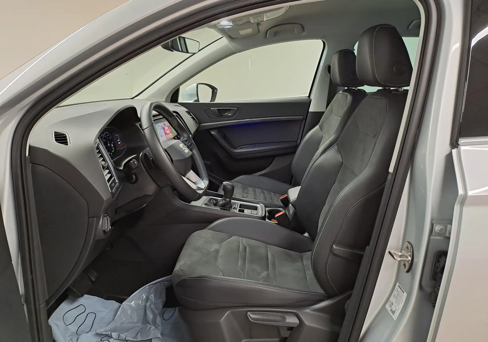 Vue intérieure côté conducteur du SEAT Ateca 2.0 TDI argent, sièges en tissu et alcantara avec console centrale visible.