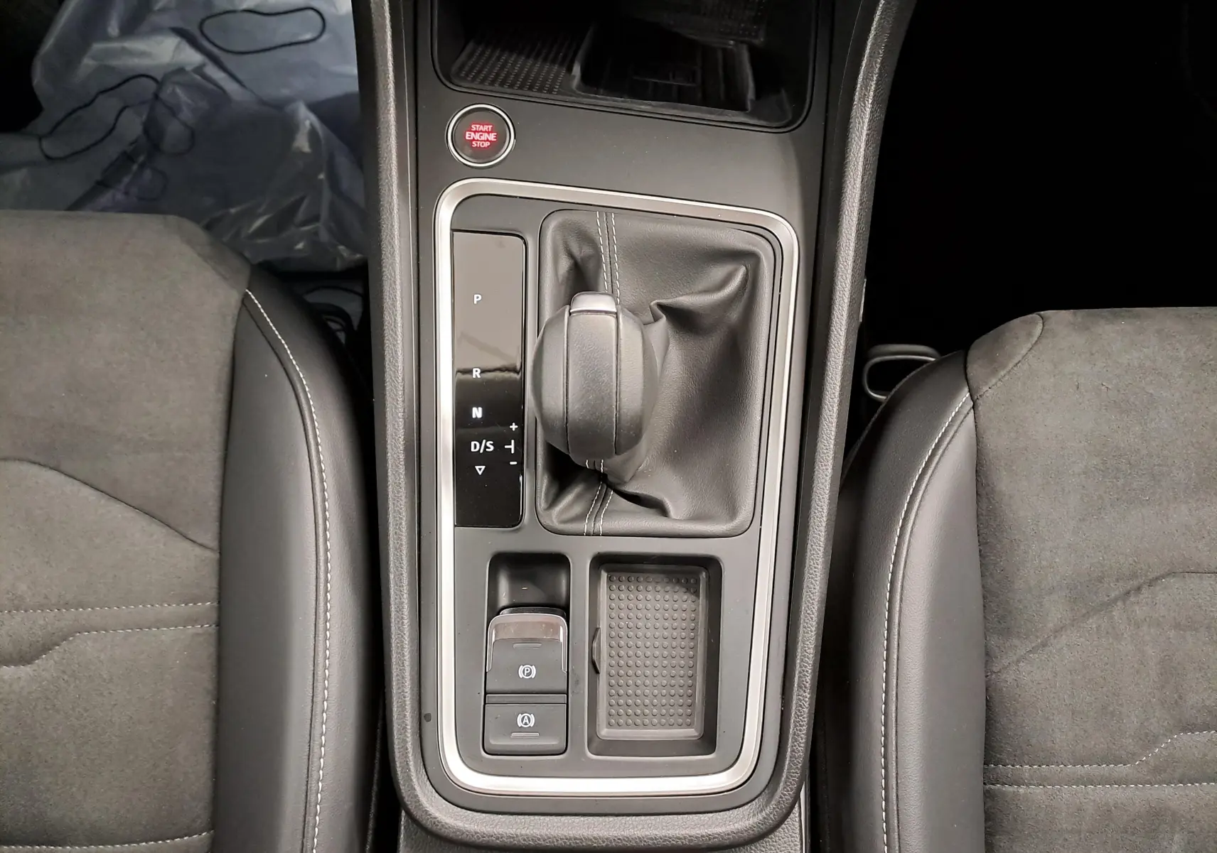 Vue plongeante sur la console centrale du SEAT Ateca 2.0 TDI 150 DSG7 avec levier de vitesse et sièges en tissu gris.