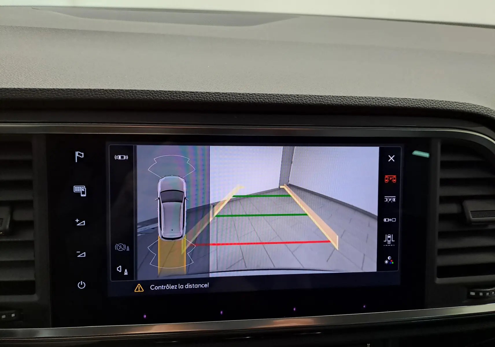 Vue écran multimédia montrant la caméra de recul du SEAT Ateca argent, avec guidage de trajectoire coloré.