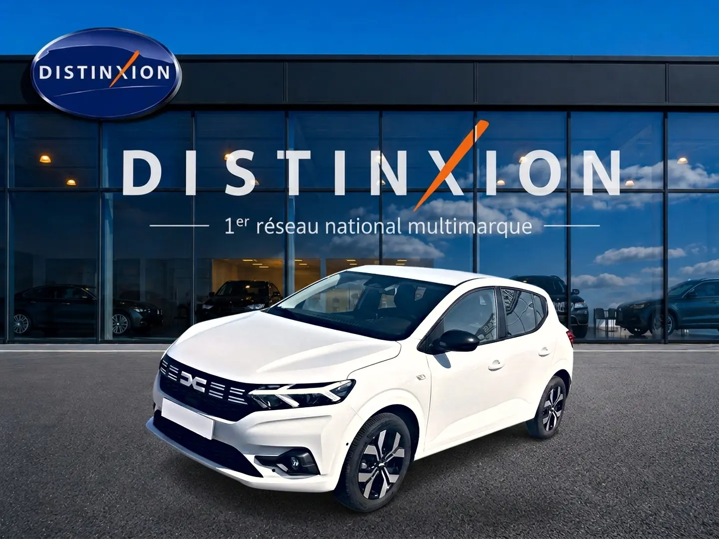 Dacia Sandero 1.0 TCe 90 Journey blanc vue 3/4 avant avec jantes alu et rétroviseurs noirs devant showroom Distinxion.