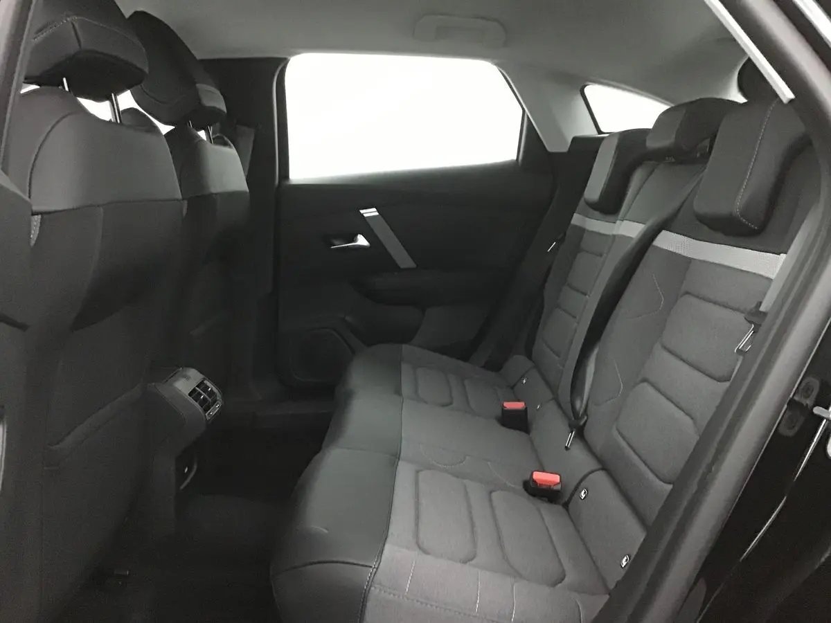 Vue intérieure arrière côté droit de la banquette arrière grise et noire du Citroën C4 noir 2022 finition Feel Pack.