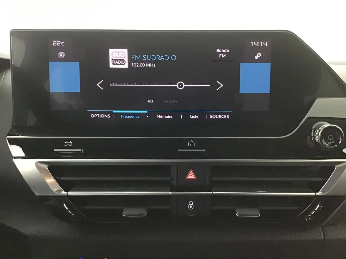 Tableau de bord du Citroën C4 noir 2022, vue frontale sur l'écran tactile affichant la radio FM Sud Radio.
