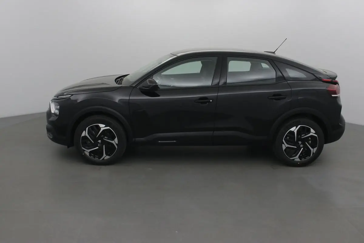 Profil côté gauche d'une Citroën C4 noire 2022 avec jantes noires et grises au design moderne.