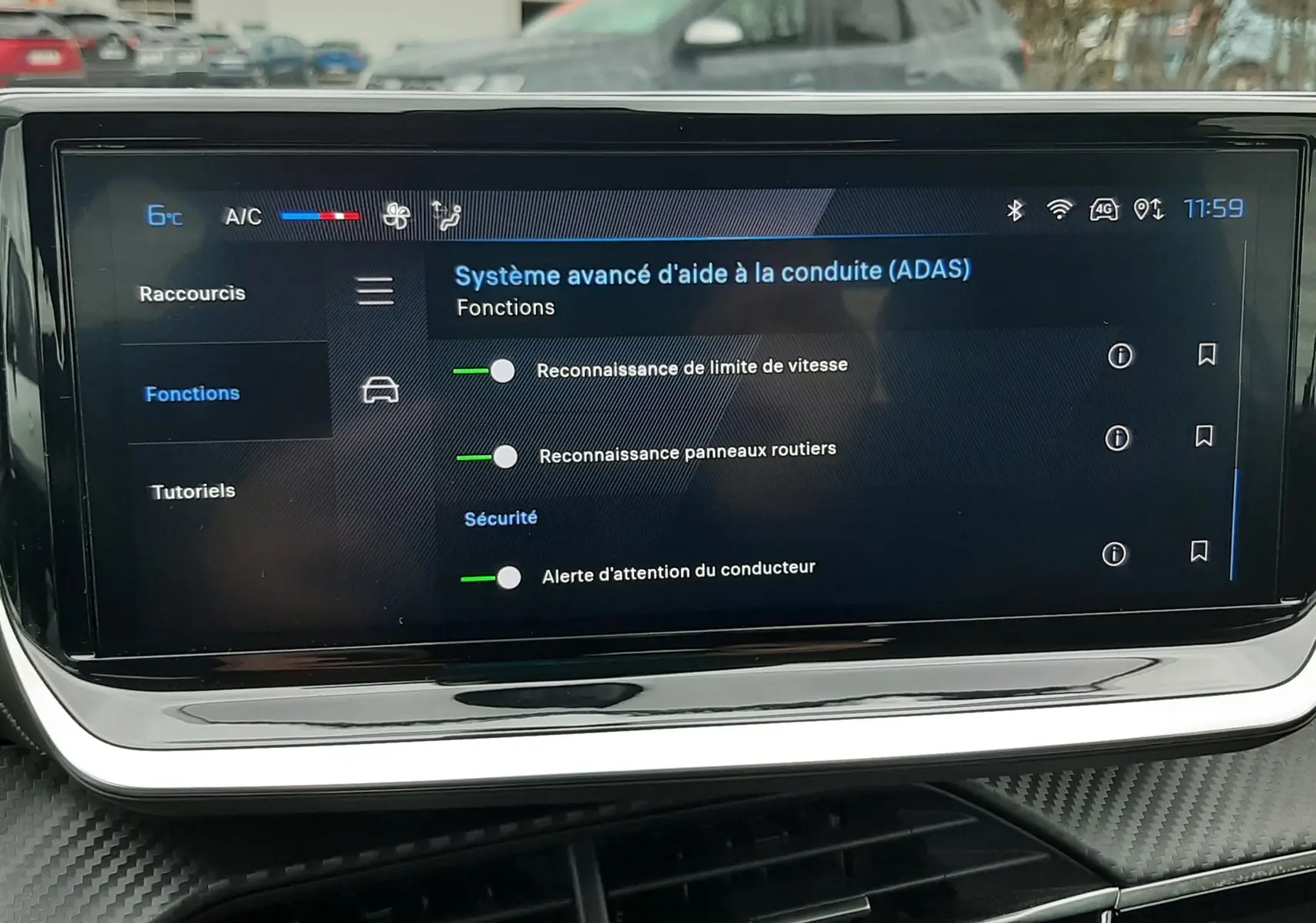 Écran tactile central du tableau de bord de la Peugeot 208 2024 affichant les aides à la conduite, avec finition gris sélénium visible.
