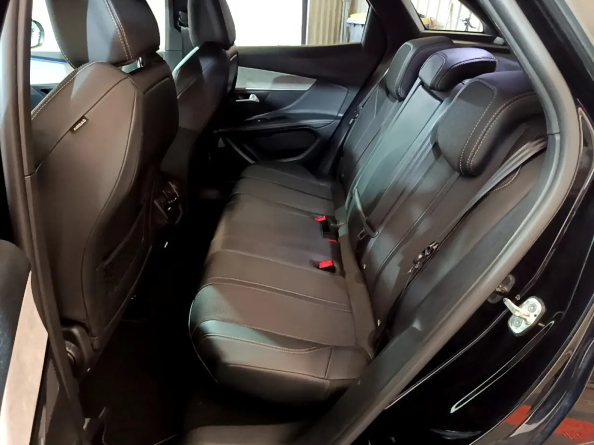 Vue intérieure côté droit des sièges arrière noirs en cuir du Peugeot 3008 GT 2023 avec surpiqûres blanches.